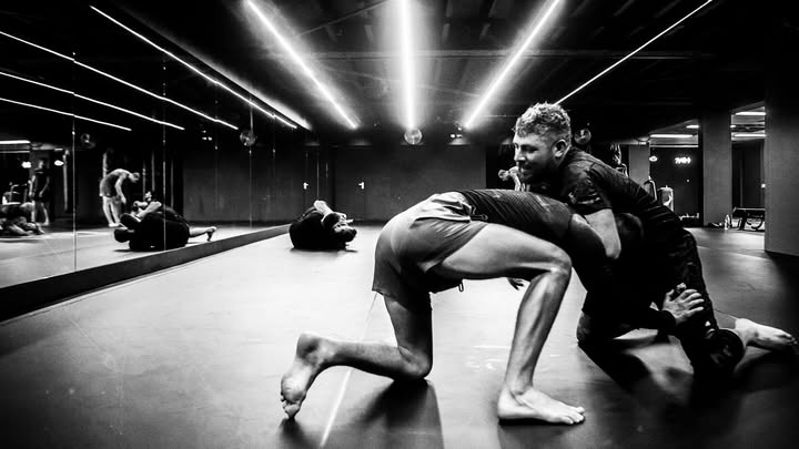 Twee sporters oefenen een techniek uit het Braziliaans jiujitsu op de mat bij Fight Ready in Zaandam.