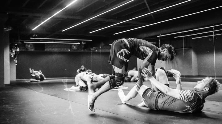 Twee sporters oefenen een guardpass tijdens een no-gi BJJ-training bij Fight Ready.